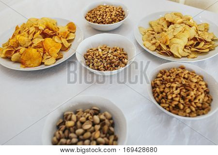 Salty appetizers lie on white plates on the table