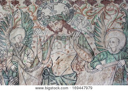 Passion scene with christ showing his bloody hands. Two angels support him. Fresco in Arhus cathedral Denmark Juni 21 2015