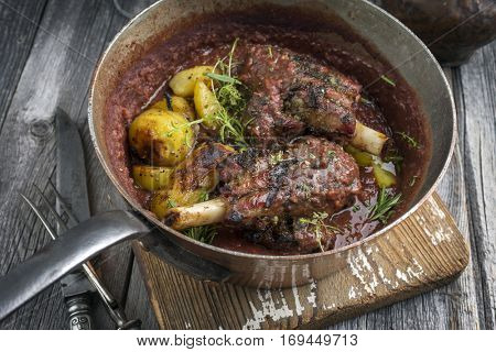 Lamb Knuckles with Potatoes in Burgundy Sauce in Casserole