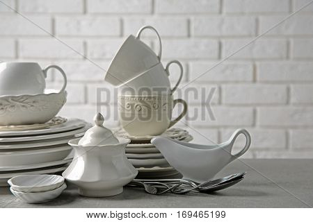 Porcelain dishware on table and white brick wall background