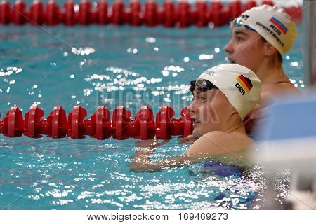 ST. PETERSBURG, RUSSIA - DECEMBER 16, 2016: Laura Riedemann of Germany and Arina Openysheva of Russia waiting for results after 200 m freestyle swimming competition during Salnikov Cup