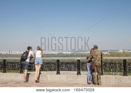 KIEV UKRAINE - AUGUST 8 2015: Ukrainian soldier on leave from the Eastern Ukraine conflict observing Kiev panorama with his girlfriend