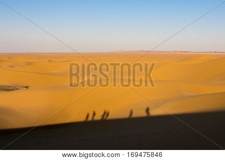 Shadows of people walking on Sand dunes in the Maranjab desert near Kashan Iran