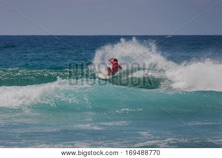 A surfer surfing in the waves doing a cutback manoeuvre