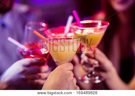 Group of friends toasting cocktail at bar counter in bar