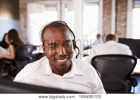 View Of Man Working In Busy Customer Service Department