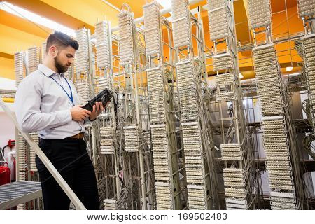 Technician using digital cable analyzer in server room