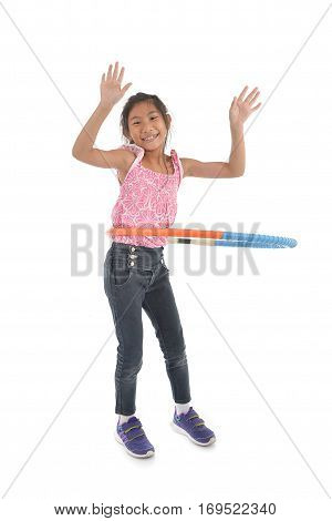 Portrait of happy little Asian child girl playing hulahoop on isolated white background