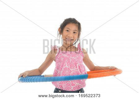 Portrait of happy little Asian child girl playing hulahoop on isolated white background