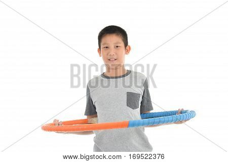 Asian boy playing with the hulahoop on a white background