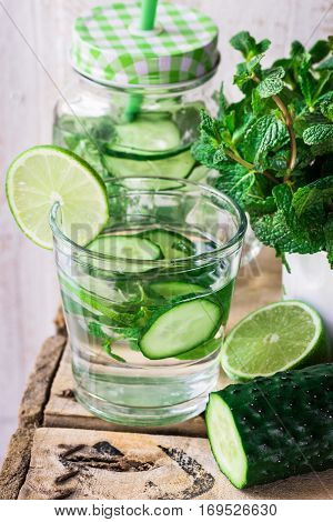 Glass jar mug with cleansing cucumber water with lime and mint ingredients agua fresca spring outdoors