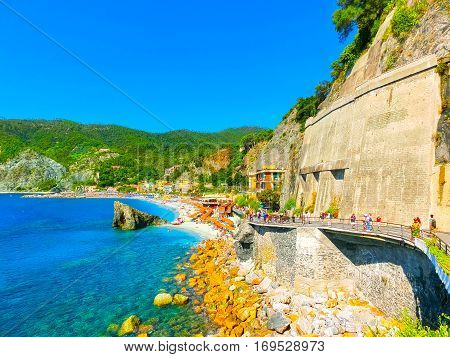 Monterosso, Italy - People on the coastline of Monterosso in Italy. Monterosso is one of five famous coastline villages in the Cinque Terre National Park.