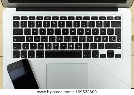 aluminum laptop and phone with a beautiful design on the wooden background keyboard