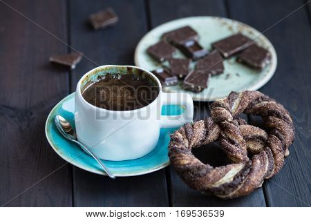 Cup of coffee with chocolate and pretzel.