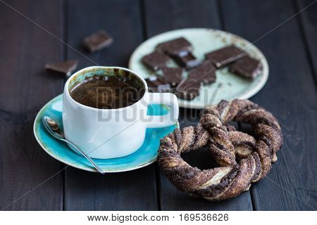 Cup of coffee with chocolate and pretzel.