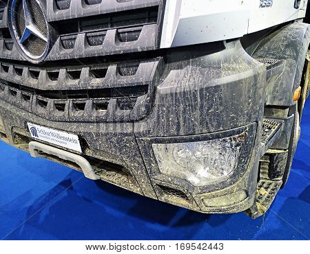 Chemnitz, Germany - October 4, 2015: Muddy front end of a truck of the type Mercedes-Benz Arocs 1851 with the typical Mercedes star. Mercedes-Benz is a trademark of vehicles of Daimler AG.