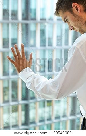 Young caucassian businessman standing against office window