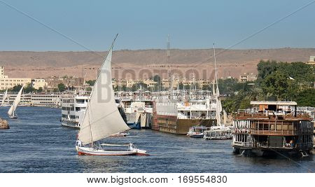The River Nile with many boats and felluca's sailing along the river taking tourists on their trip along the Nile in Egypt