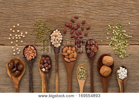 Different Kind Of Beans And Lentils In Wooden Spoon On Wood Background. Mung Bean, Groundnut, Walnut