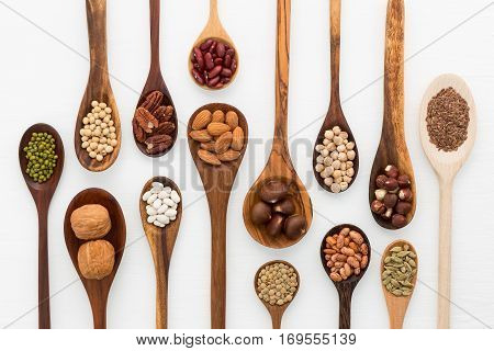 Different Kind Of Beans And Lentils In Wooden Spoon On White Wood Background. Mung Bean, Groundnut,