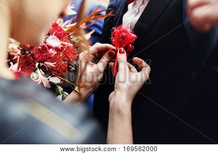 Tender Woman's Hands Piut A Boutunniere On Black Jacket