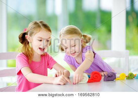 Two Cute Little Sisters Having Fun Together With Modeling Clay At A Daycare. Creative Kids Molding A