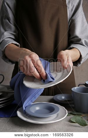 Closeup of female hands cleaning saucer