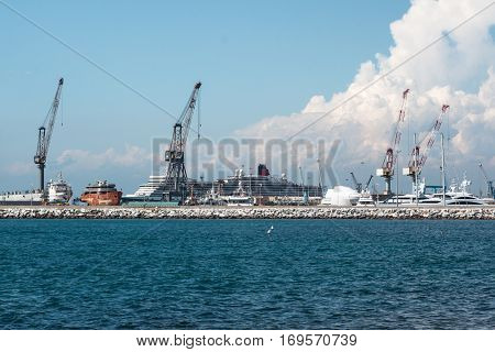 Cranes at Work in Boatyard near Lighthouse