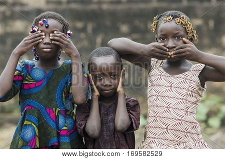 Young african girls and boy posing as famous three wise monkeys