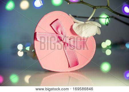 gift box in form of heart on the background of the white orchid