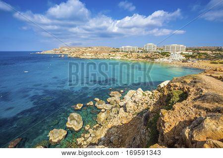 Ghajn Tuffieha Malta - Panoramic skyline view of Golden Bay Malta's most beautiful sandy beach on a nice summer day with blue sky and clouds