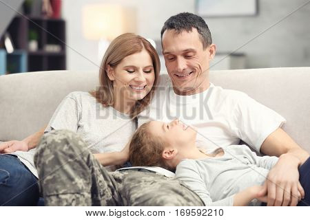 Military father with his family on sofa at home