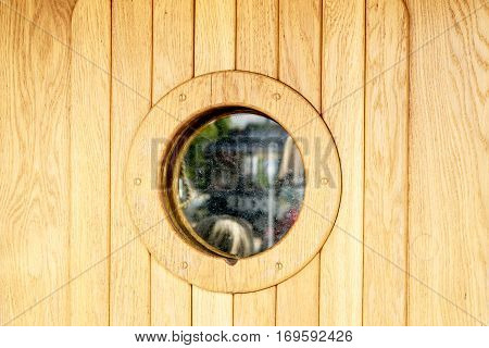 Marine ship window or porthole on wooden wall