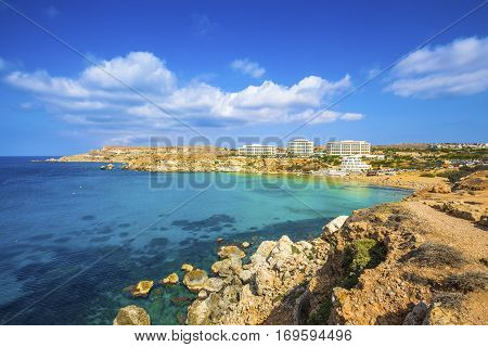 Ghajn Tuffieha Malta - Panoramic skyline view of Golden Bay Malta's most beautiful sandy beach on a nice summer day with blue sky and clouds