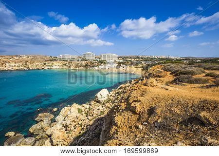 Ghajn Tuffieha Malta - Panoramic skyline view of Golden Bay Malta's most beautiful sandy beach on a nice summer day with blue sky and clouds