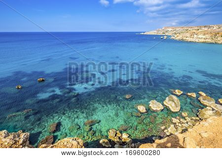 Ghajn Tuffieha Malta - Panoramic skyline view of Golden Bay Malta's most beautiful sandy beach on a nice summer day with blue sky and clouds