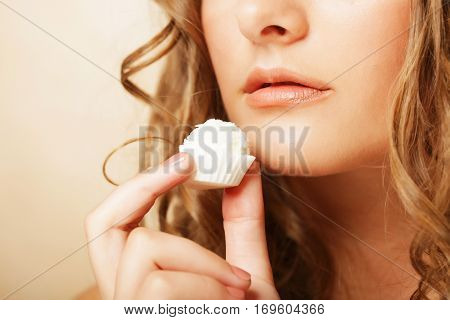 beauty portrait of a cute  girl in act to eat a candy with cocoanut