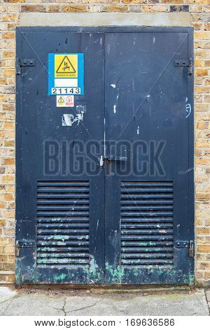 rusty iron door that gives acess to electrical board of a building. with signs of danger and prohibitions of smoke in it