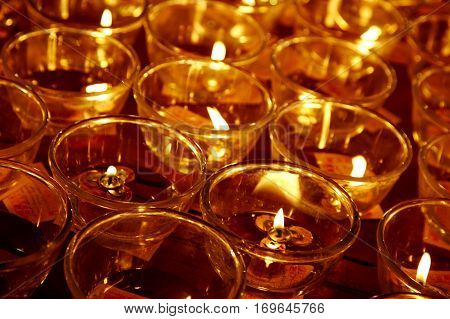 Vintage retro effect filtered hipster style travel image of burning candles in Buddhist