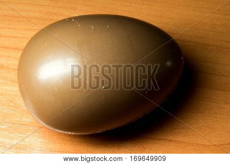 chocolate egg on a wooden table background.