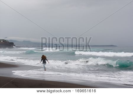 girl run ocean atlantic volcanic beach nature Portugal Azores island waves landscape