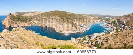 Beautiful view of the Black Sea and the city Balaklava. Balaklava Bay. Genoese fortress in mountains. Clear summer day and a top view of the port