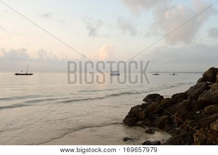 Several dhow on the ocean at sunrise on Bamburi beach in Kenya