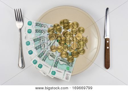On The Plate Is A Bunch Of Russian Ten-thousandths Of Bills And Coins Lay Near Cutlery, Top View