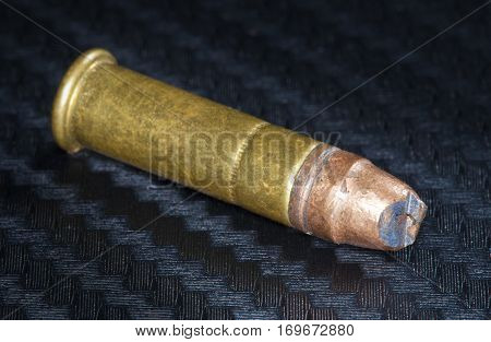 Rimfire cartridge on graphite that has had its bullet bent
