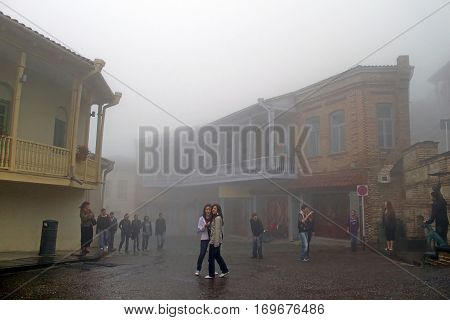 SIGHNAGHI, GEORGIA - OCTOBER 10, 2010: Teenagers are on the excursion in Sighnaghi in foggy weather, Georgia. Sighnaghi is a town in Georgia's easternmost region of Kakheti and the administrative center of the Sighnaghi Municipality