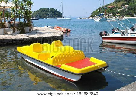 PAXOS, GREECE - JUNE 10, 2014: A bright yellow pedalo moored in the harbour at Lakka on the Greek island of Paxos. Just 13km long, the small Ionian island has a population of circa 2300.