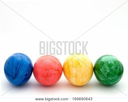 Four colored Easter eggs: blue, red, yellow and green.