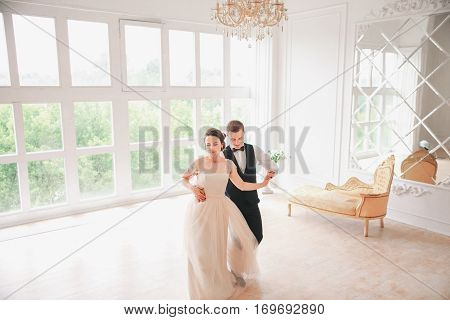 wedding couple dances first dance on the studio. Wedding day. Happy young bride and groom on their wedding day. Wedding couple - new family. Wedding dress.