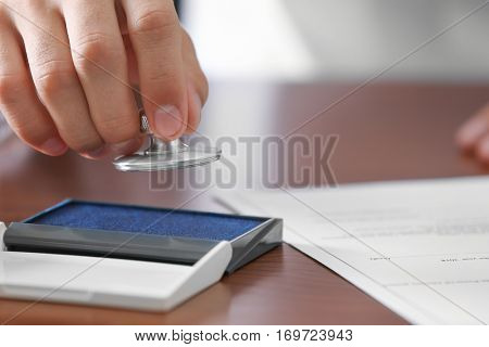 Notary public pressing stamp into ink pad